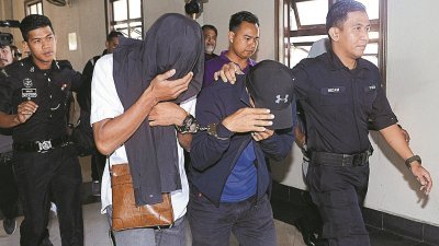 身穿白衣T恤的瑟尔曼（右3）和穿蓝衣的法依扎（右2）被 带上吉隆坡地庭面控时，用帽子和衣服遮脸，闪避摄影记者 的镜头。