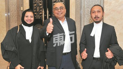 三苏峇林（中）在法庭判决他无罪获释后，与律师扎丽娜 （左起）及海真奥玛步出法庭，并向记者比起大拇指。 （摄影：连国强）
