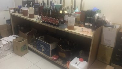 警方在住宅单位内发现疑似制造假酒的各类器具。