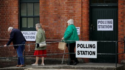 英格兰大曼切斯特城镇赛尔的选民，在投票后离开投票站。英格兰及北爱尔兰两地，将改选8245个议席。
