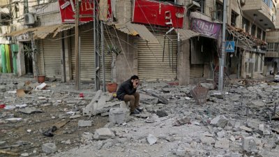 以军轰炸哈马斯控制的加沙地区，市内多处冒起浓烟，不时传出爆炸声，多幢房屋损毁。这是当地一名巴勒斯坦人翌日在碎石满地，如同废墟的街道上坐著愁眉苦脸。
