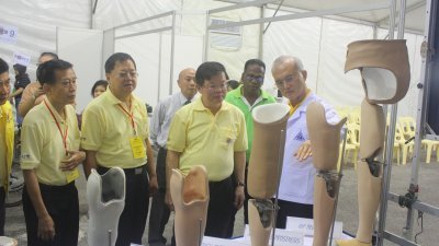 紫云阁阁长拿督林嘉水（左起）、黄智绪和曹观友，聆听泰国皇太后义肢基金会总秘书长黄成立介绍各项义肢的类型。
