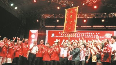 方炎华（左7）及林冠英（左8）移交圣旗予第12届世界大伯公节庆典的承办单位澳门庙宇节庆文化促进会。