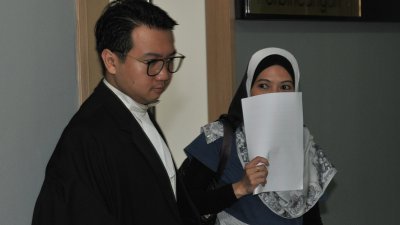 第三名答辩人阿都拉萨的秘书西蒂艾莎完成供证后，在律师的陪同下离开法庭时，用文件遮盖面部，不愿样貌曝光。
