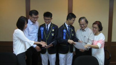 谭永翔（左3起）和程俊里向各自的父母展示得奖证书。左起为曾华斌、谭家隆、程家强和李丽萍。（摄影：黄俊南）
