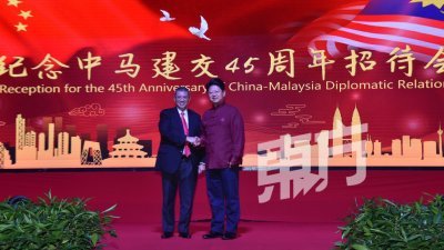 赛夫丁（左）代表大马政府出席中国驻马大使馆举行的中马建交45周年招待会，并与白天（右）握手互相祝贺。（摄影:曾钲勤）
