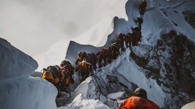 珠峰登山季接近尾声，周一再传出一名美国登山客罹难，让近日罹难登山客的人数达到11人。这是在珠峰攻顶路上排长龙的民众，他们的脚下赫然就是一具登山客的遗体。
