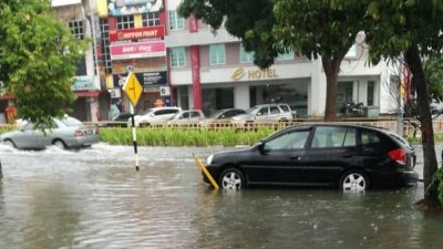 由于路面淹水，一些车辆涉水而过，有者则抛锚在路中。