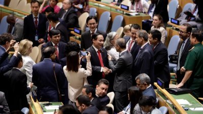 越南在联合国大会选举中，当选安理会非常任理事国，出席会议的代表轮流与越南副外长黎怀忠（中）握手道贺。