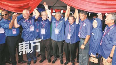 纳吉（左2起）、魏家祥、阿末扎希与莫哈末哈山等国阵领袖在提名中心外高举代表国阵上阵的马华候选人黄日昇双手，以示支持。（摄影：刘维杰）