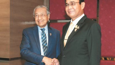 马哈迪（左）与泰国首相巴育（右）在第35届东盟峰会前的双边会谈上握手。