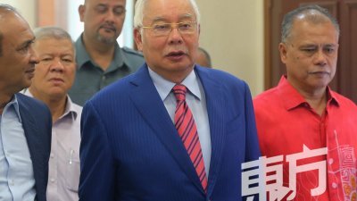 纳吉（中）周二到吉隆坡高庭出席1MDB稽查报告遭篡改案的审讯。（摄影：骆曼）