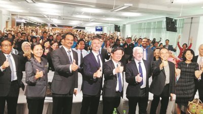 拉惹（左3起）、艾力克、曹观友和亚莱斯，于周四在宣布美国国家仪器公司将在槟城扩建厂房的消息后与员工们合影。