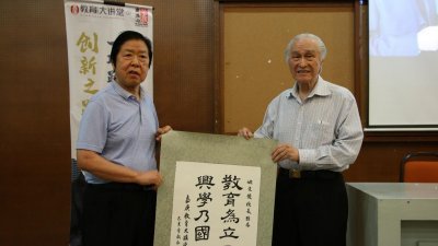 马来西亚陈嘉庚基金发起人之一陈凯希（右）代表大会赠送“嘉庚语录”墨宝予姚文俊。