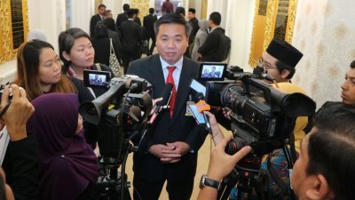 郑国球（中）在甲州议会走廊接受媒体访问。