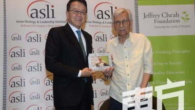 亚洲策略和领导研究院（ASLI）主席丹斯里谢富年（左）赠送纪念品予敦达因。(摄影：陈启新）