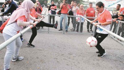 阿末费沙（右）一时兴起，与民众一起进行真人版的桌上足球游戏。