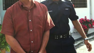 凯鲁尼占（左）被控暴力对待一名锡克籍医生后被带离法庭。