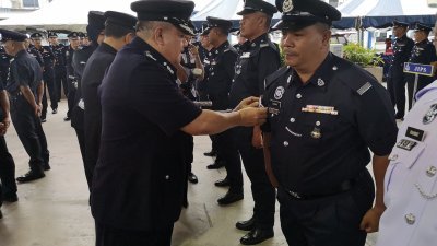 在月常集会上，罗斯里（左）为获得升迁的警官及警员配戴警阶肩章。