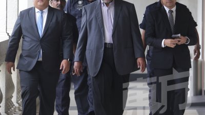 罗海扎阿末（中）周三被控上法庭，面对33项贪污控状。（摄影：骆曼)