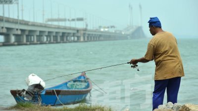 尽管周三阴霾笼罩，但在槟城大桥一带作业的渔民仍照旧出海。（摄影：蔡开国）