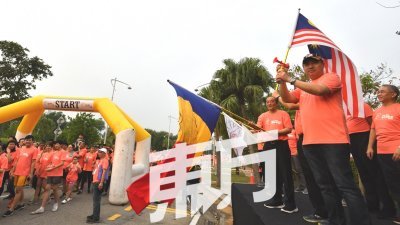陆兆福（右）挥动国旗，为“2019和平之跑”主持开跑仪式。右2为许锡辉。（摄影：张真甄）