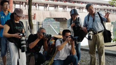 中国政府被抨骚扰和随意拘禁记者及其家人。图为中国著名摄影师卢广妻子周一在推特发布的照片显示，在新疆失联近一年的卢广（右）在户外指导几位摄影师拍照。

