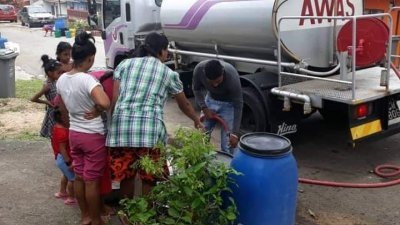 水务公司派出水槽车到受影响的地区派水，居民正准备提水。