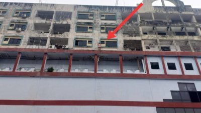 年约30岁的女子在建筑物5楼阳台外企图跳楼轻生，处境十分惊险。(图由消拯局提供)
