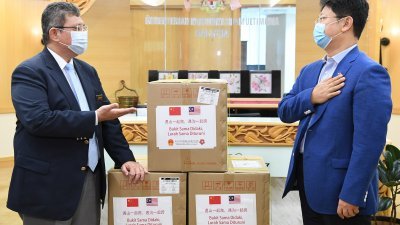 赛夫丁阿都拉（左）向白天致谢，感谢中国使馆所捐赠的口罩。