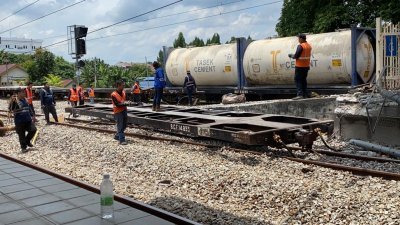货运火车发生车厢脱轨意外后，马来亚铁道公司立即派员把脱轨翻覆的车厢移走。