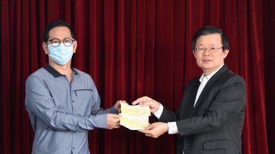 曹观友（右）接领江伟铭代表Best Group（mm2h）有限公司献捐予槟城新冠肺炎基金的15万令吉支票。