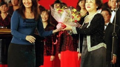第四届中国国际合唱节1998年7月25日在北京开幕，图为担任新加坡华文报合唱团指挥朱承安（右）及合唱团在演出后向观众致意。