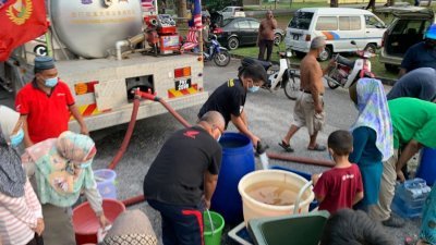 双溪大年义务消防队在庆隆花园派水给市民。