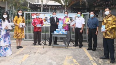 锺赐财（左4）代表林桂亿移交体温感应器及口罩给新光学校许初俊校长接领（左5），左3为林进兴市议员。
