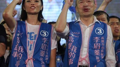 韩国瑜（右）在周五晚的选前之夜，冒著大雨力挺国民党高雄市长补选候选人李眉蓁。