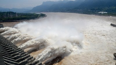 中国6月开始出现严重汛情，这是7月31日三峡枢纽开启泄洪深孔泄洪。（图取自中新社）