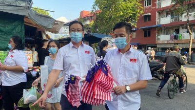 刘华才（左起）与胡栋强周日前往双溪槟榔区，派发小国旗予当地民众。（图取自面子书）
