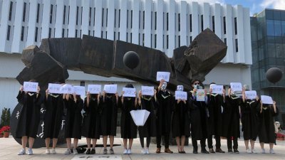 香港中文大学上月举办网上毕业典礼，有毕业生在校园内高喊拉起横幅并高喊“光复香港，时代革命”等口号，也有人高举遭中国海警扣押的12名涉嫌偷渡的港人名字（图）。-路透社-