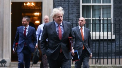 英国首相约翰逊（中）周二披露，英方必须承认，是时候选择无协议脱欧和放弃谈判的时刻可能会到来。这是他当天在伦敦的首相府外步行。（图取自路透社）