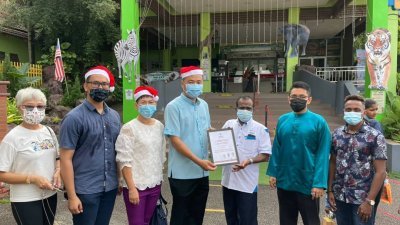 郑国球（右2）在马六甲动物园颁发圣诞礼物予武吉峇汝儿童之家的孩童，右起为傅秋霞及卡塞尔。