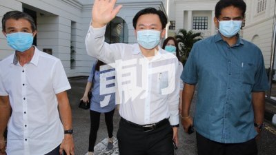 杨祖强（中）在步离怡保高庭时，向媒体挥手打招呼。