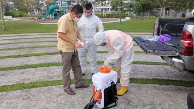 陈勇鸣（左）协助黄日昇安排工作人员，到出现新冠肺炎确诊病例的住宅区喷洒消毒药水。