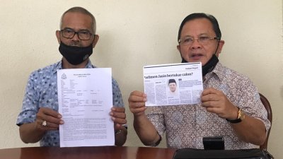 阿末韩查（右）展示有关马来报导，指本身无意在下届大选上阵，左起卡查里。
