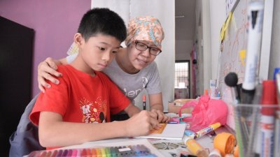 黄慧婷（右）平时会陪伴儿子做功课、练习画画；儿子的乖巧懂事，也令她倍感欣慰。（摄影：曾钲勤）