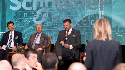 首相敦马哈迪（左2）周一出席由大马法国工商会主办的对话会，回答出席者的提问。左起：大马法国工商会主席拿督再纳和吉尔斯。