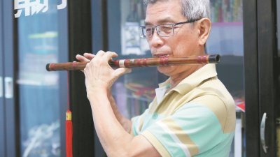 覃友习得笛子多年，虽未曾表演，却仍非常钟爱吹奏笛子。（摄影：刘维杰）