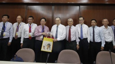 郑奕南（左6）在日新董事部成员的陪同下，赠送纪念品给刘利民（左5）。