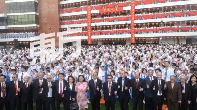 林景清（前排右9）与一众教职人员，还有董事会理事，在隆中华的中华广场，与学生们合照留念。（摄影：陈启新）