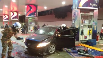 肇祸的黑色本田城市轿车车头损坏严重，油站添油处因遭到撞击而出现损坏。（图由消拯局提供）